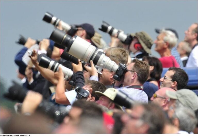 Spectators and photographers are seen through a heat haze as they attend the Farnborough Airshow